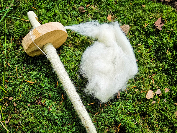 TRIBE making a drop spindle from natural materials with wool