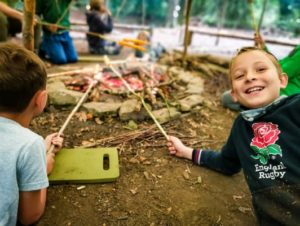 TRIBE Bushcraft child adventure day cooking bread twists over the fire