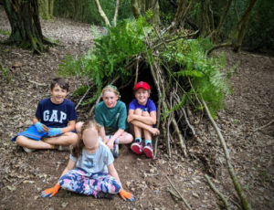 TRIBE Bushcraft child adventure day session children showing their completed mini shelter