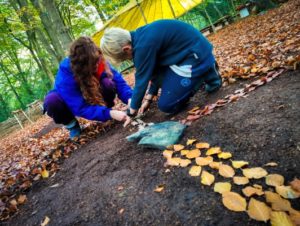 TRIBE Bushcraft child adventure day session instructor and child making leaf art