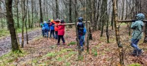 TRIBE Bushcraft home school education session carrying logs back to camp