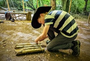 TRIBE Bushcraft home school education session child tying sticks together with jute