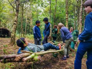 TRIBE Bushcraft home school education session children demonstrating the bushcraft stick hammock