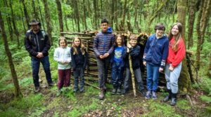 TRIBE Bushcraft home school education session children near an abandoned bushcraft shelter