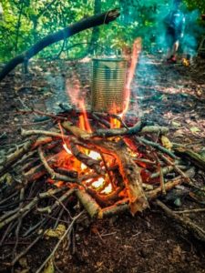 TRIBE Bushcraft session adventure day boiling filtered water in a tin can above a fire