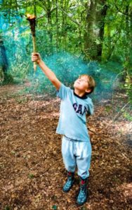 TRIBE Bushcraft session adventure day child holding a bushcraft torch using birch bark and a hazel rod