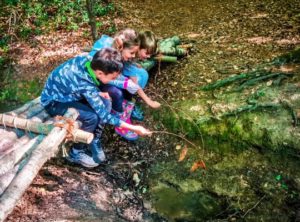 TRIBE Bushcraft session adventure day children playing with the willow woven fish they created