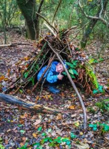 TRIBE Bushcraft session birthday party child demonstrating a completed mini shelter