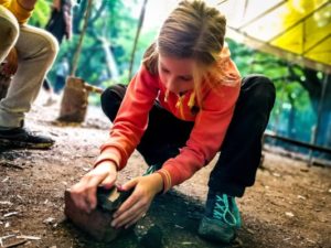 TRIBE Bushcraft session discovery day using rocks to crush charcoal for a water filter