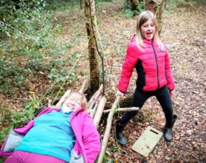 TRIBE Bushcraft session social saturdays family bushcraft child and an adult testing out the stick hammock