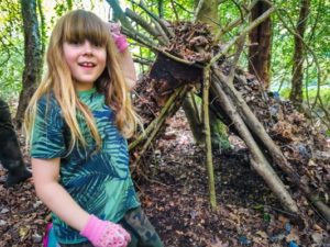 TRIBE Bushcraft session social saturdays family bushcraft child showing her completed shelter