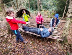 TRIBE Bushcraft session social saturdays family bushcraft children and an adult testing out the stick hammock