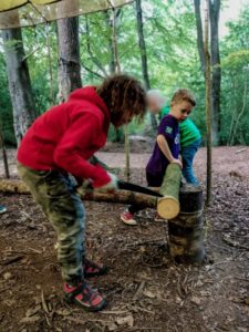 TRIBE Bushcraft session social saturdays family bushcraft children cutting lengths of a log for their bushcraft cup