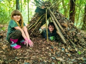 TRIBE Bushcraft session social saturdays family bushcraft children showing their completed shelter