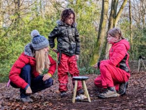 TRIBE Bushcraft session social saturdays family bushcraft pancackes being made over a small fire and 3 green sticks