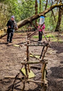 TRIBE Bushcraft session social saturdays family bushcraft stick tower holding a fizzy drinks can