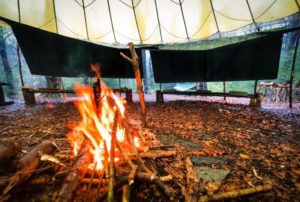 TRIBE Bushcraft session social saturdays family bushcraft tarps providing extra shelter in the main camp