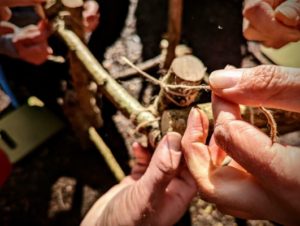 TRIBE Bushcraft session social saturdays family bushcraft tying the stick tower together with jute