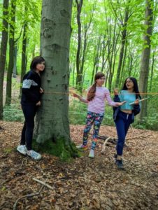 TRIBE Bushcraft child discovery day children putting up a ridge line for a shelter