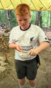 TRIBE Bushcraft session social saturdays family child using a whimmy diddle toy